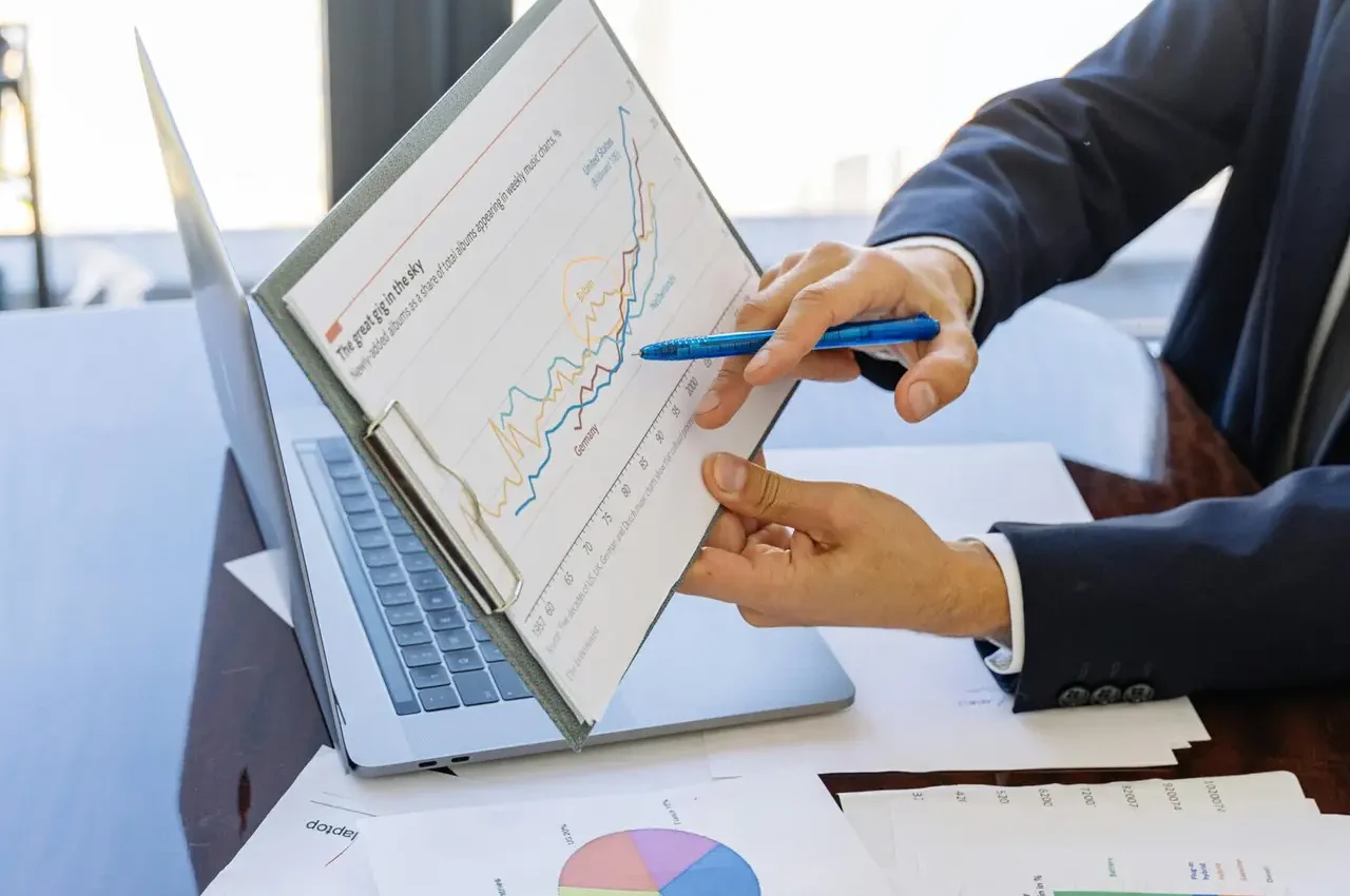 Business professionals discussing financial graphs and charts in an office setting.